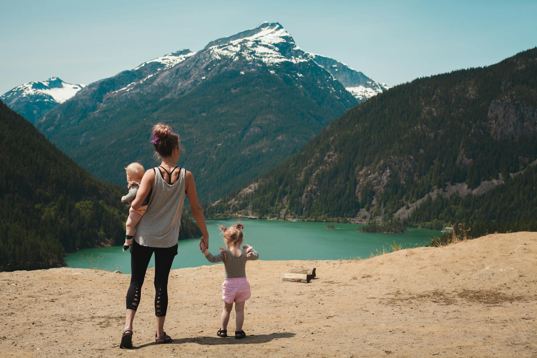 mother and children walks near body of water